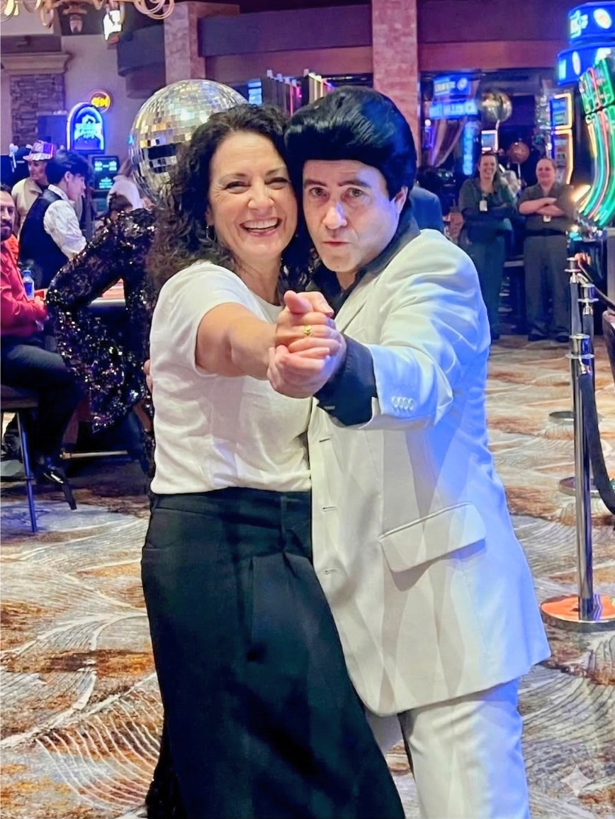 Tony posing cheek to cheek with a guest during a disco-themed casino party.