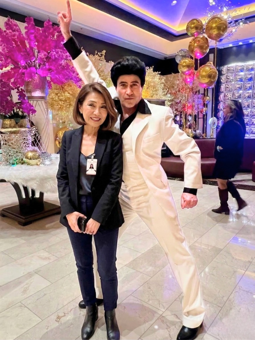 Tony striking the classic Saturday Night Fever finger-point pose at a casino event.