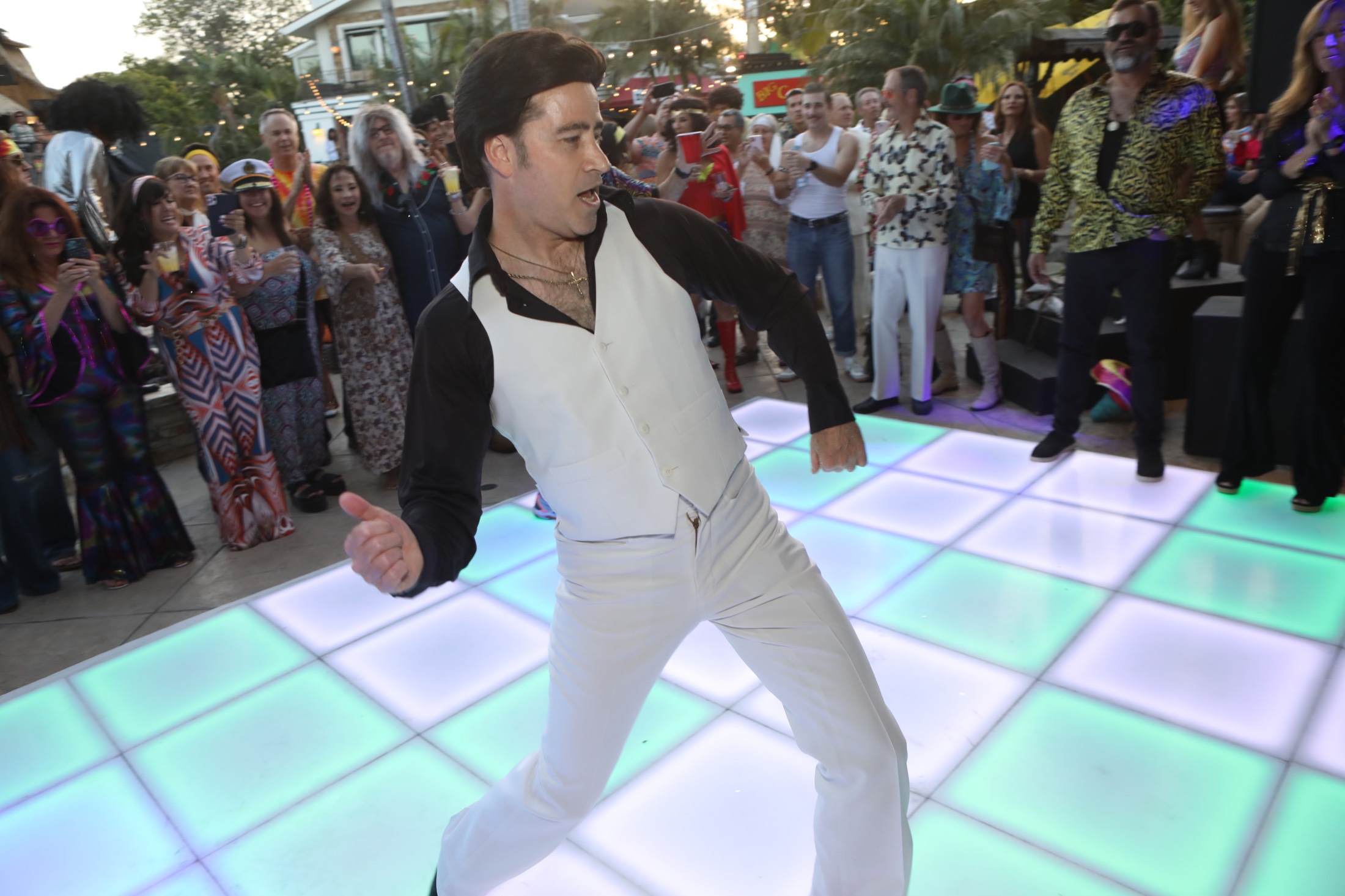 Tony performing disco dance moves during a Saturday Night Fever tribute at a party.